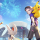 A Pokémon trainer with a Pikachu on his shoulder beckons the viewer towards a stadium as fireworks explode overhead